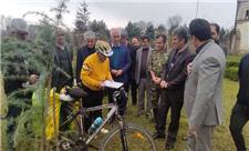 دوچرخه سوار گیلانی که برای کاشت نهال رکاب می زند